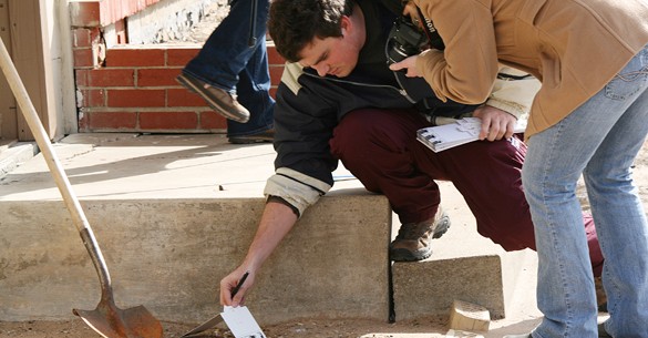 students look for evidence at a mock crime scene