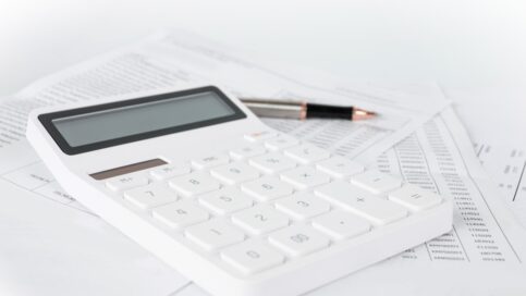 Image of a calculator, pen, and paper