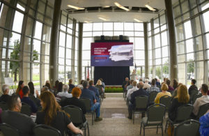 A presentation being held in the AgriLife Center. There are people in attendance, sitting in rows facing the screen. The screen is displaying a presentation entitled: "Automated Precision Phenotyping (App) Greenhouse". The speaker is using the podium.