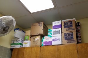 Image of cardboard boxes stored on top of a wall cabinet. 